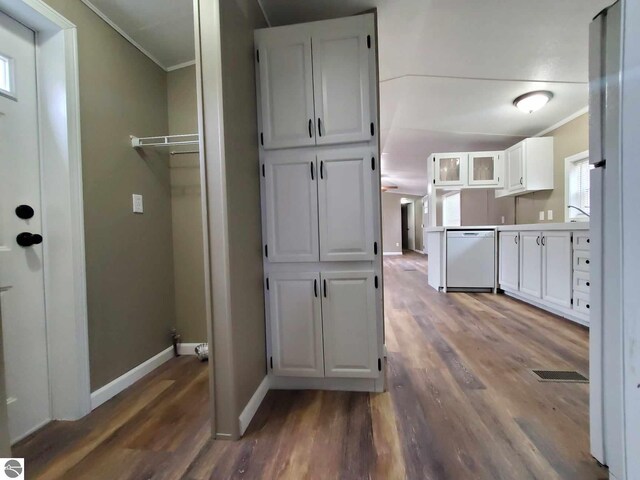 interior space featuring crown molding, white cabinetry, dishwasher, and dark wood-type flooring