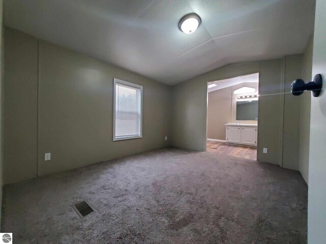 interior space featuring carpet floors and vaulted ceiling