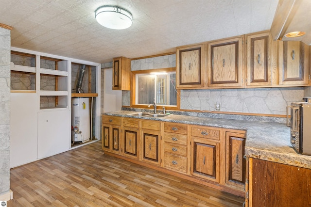 kitchen featuring light wood-type flooring, backsplash, water heater, and sink