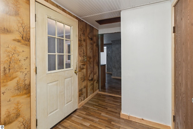 hallway with hardwood / wood-style flooring and wooden walls