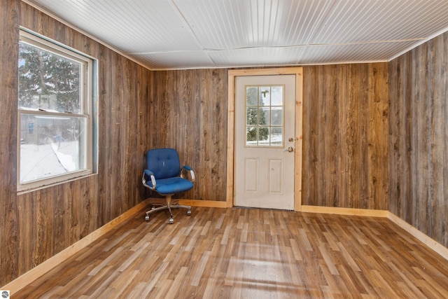 unfurnished room with wood walls and wood-type flooring