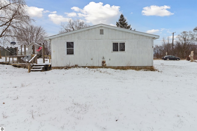 snow covered property with a wooden deck