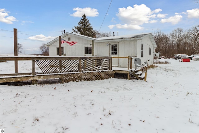 snow covered property with a wooden deck