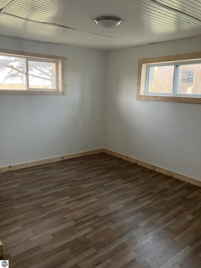 spare room featuring dark hardwood / wood-style floors and plenty of natural light