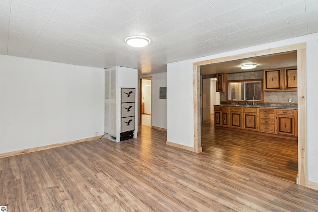 unfurnished living room with hardwood / wood-style flooring and sink