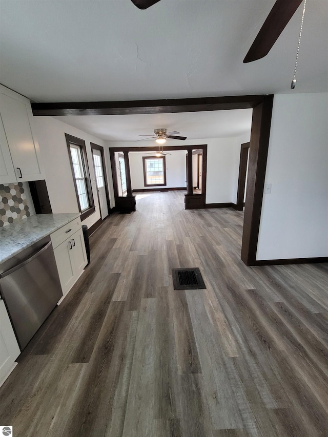 unfurnished living room with beamed ceiling, dark hardwood / wood-style floors, and ceiling fan