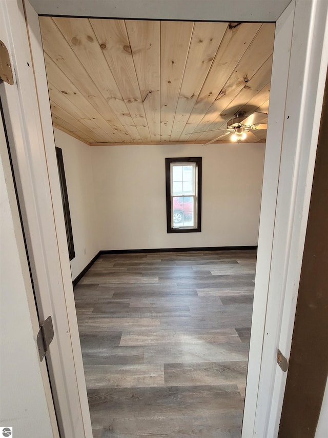 spare room featuring wood-type flooring, ceiling fan, and wooden ceiling