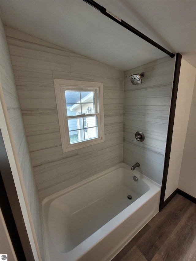 bathroom with hardwood / wood-style floors and tiled shower / bath combo