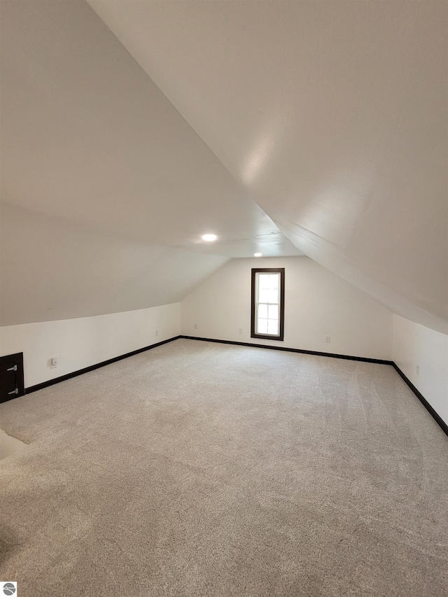 additional living space with carpet floors and lofted ceiling