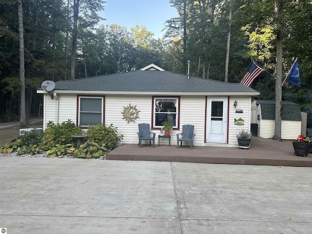 ranch-style house featuring a storage shed and a deck