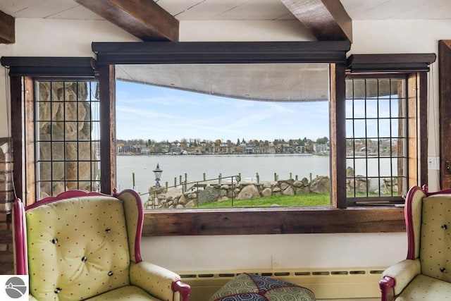 interior space featuring beam ceiling, a water view, and multiple windows