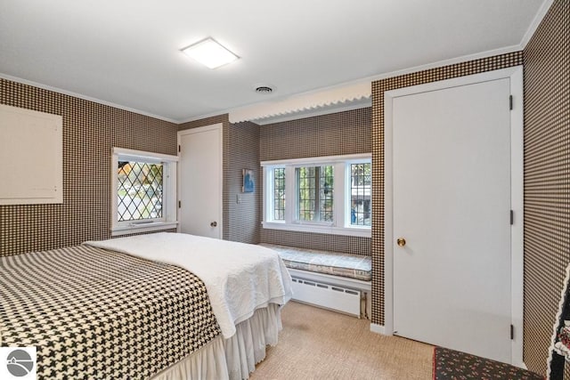 carpeted bedroom featuring ornamental molding and a baseboard heating unit