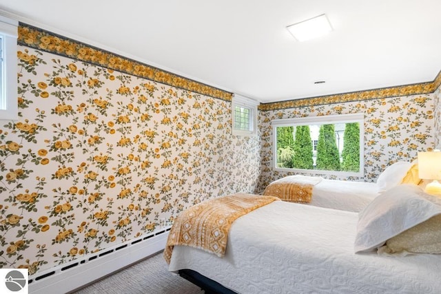 bedroom with carpet floors and a baseboard heating unit