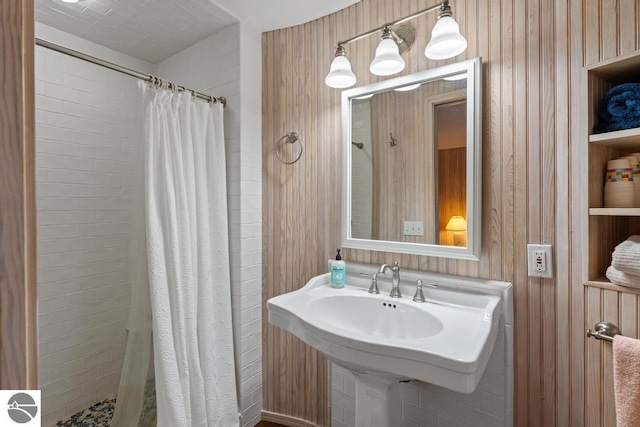 bathroom with curtained shower and wood walls