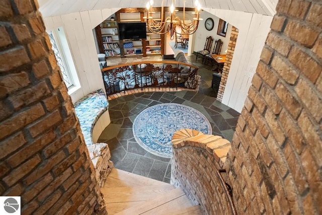 hallway featuring lofted ceiling, a chandelier, wood-type flooring, and wood walls