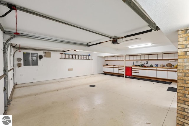 garage featuring electric panel and a garage door opener