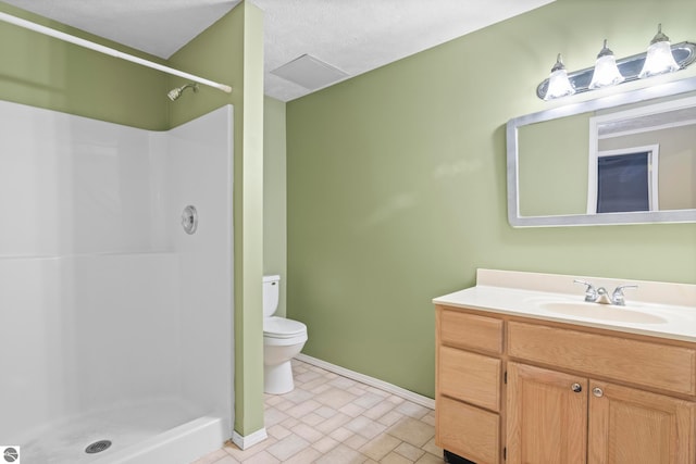 bathroom with a textured ceiling, vanity, toilet, and walk in shower