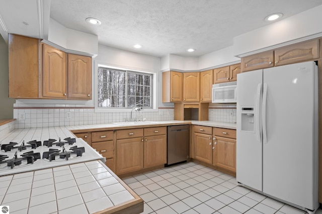 kitchen with tile countertops, white appliances, sink, decorative backsplash, and light tile patterned floors