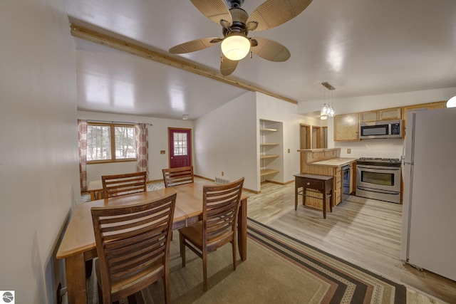 dining space featuring ceiling fan, vaulted ceiling, and light wood-type flooring