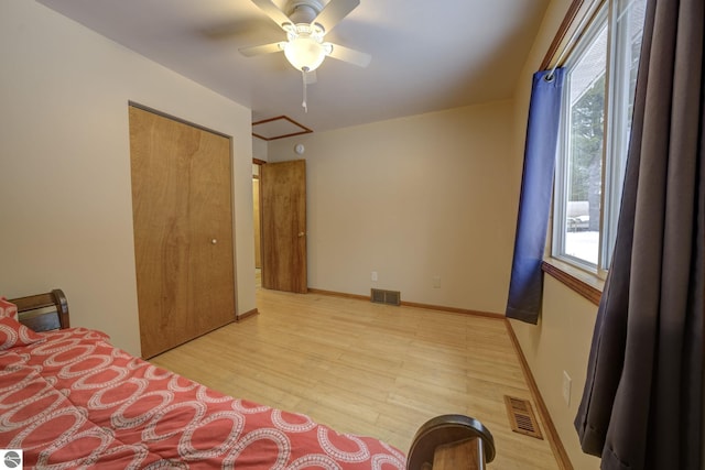 unfurnished bedroom with a closet, light hardwood / wood-style flooring, and ceiling fan