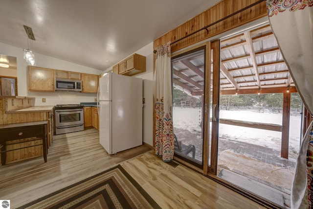 kitchen featuring decorative light fixtures, stainless steel appliances, light hardwood / wood-style flooring, and lofted ceiling