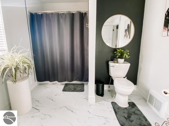 bathroom featuring a shower with curtain and toilet