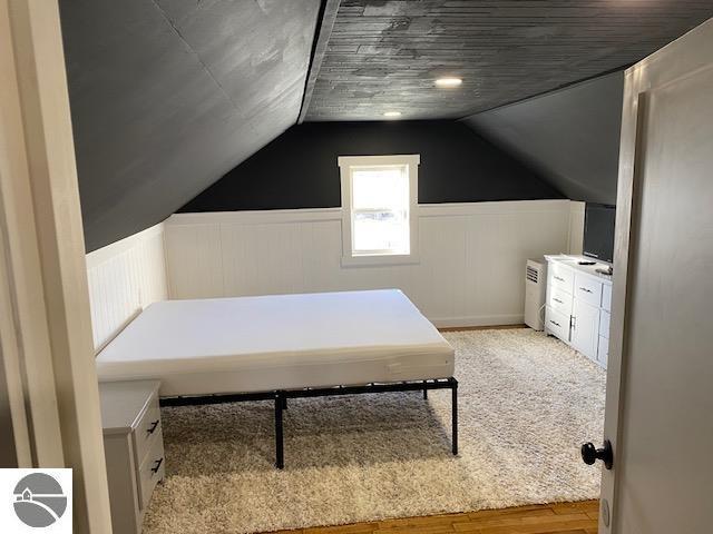 bedroom featuring light hardwood / wood-style floors and lofted ceiling