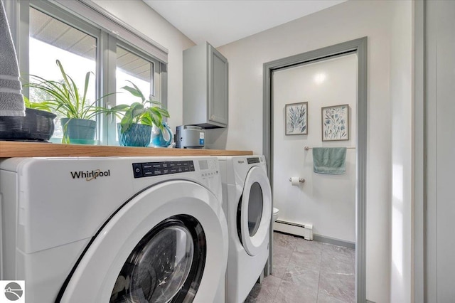 laundry room with cabinets, a baseboard radiator, and separate washer and dryer