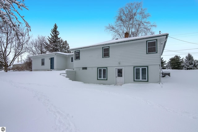 view of snow covered rear of property