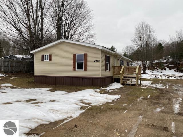 snow covered property with a deck