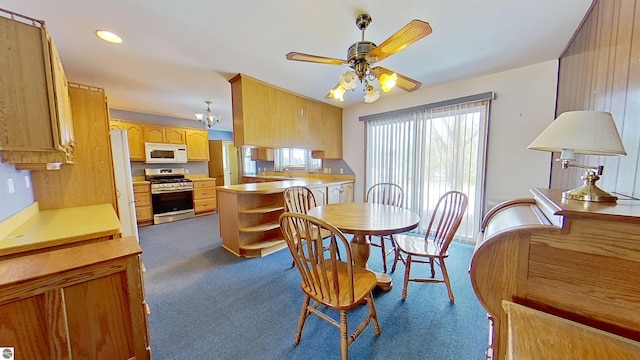 carpeted dining area featuring ceiling fan with notable chandelier and sink