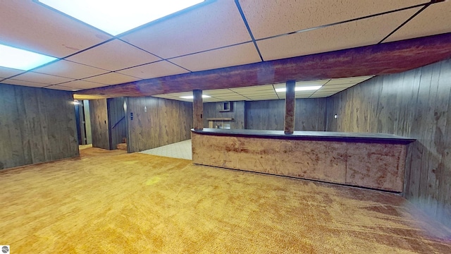 bar with a paneled ceiling, carpet floors, and wood walls