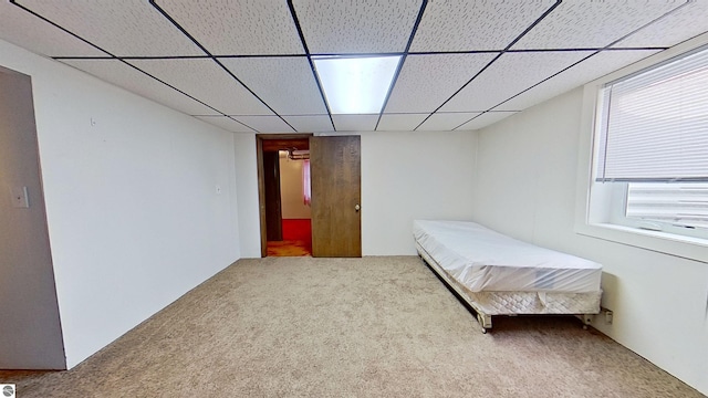 unfurnished bedroom featuring carpet and a paneled ceiling