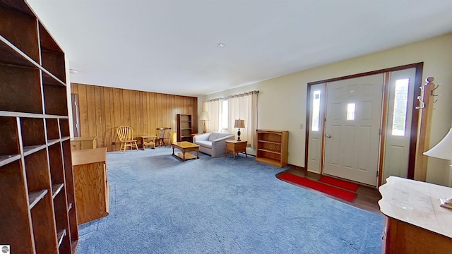 entryway featuring dark colored carpet and wood walls