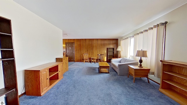 carpeted living room featuring wood walls