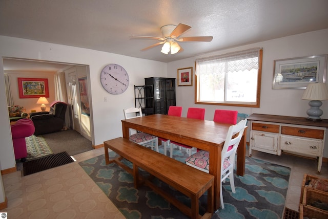 dining space featuring ceiling fan and a textured ceiling