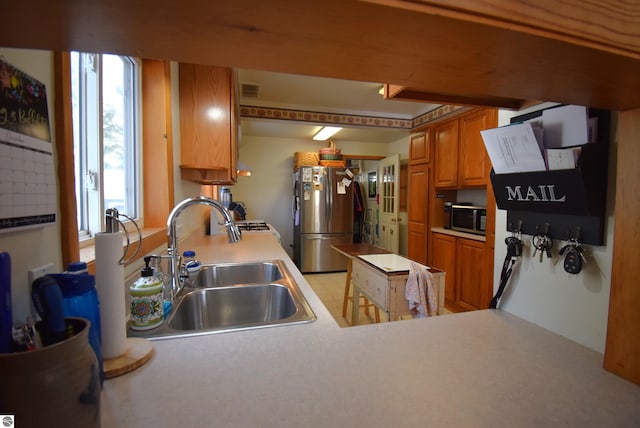 kitchen featuring kitchen peninsula, sink, and appliances with stainless steel finishes