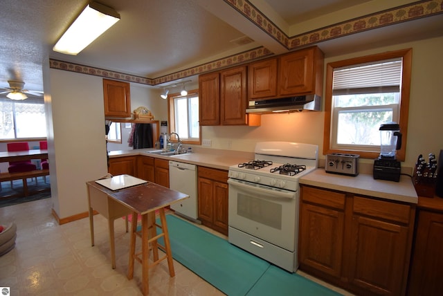 kitchen with a textured ceiling, ceiling fan, white appliances, and sink