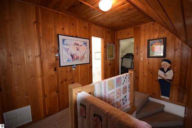 interior space with wood walls, wooden ceiling, carpet floors, and vaulted ceiling