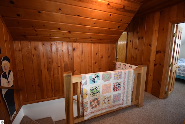 interior space featuring wood walls, light colored carpet, and vaulted ceiling