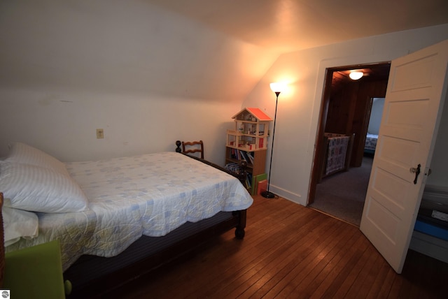 bedroom featuring wood-type flooring and vaulted ceiling