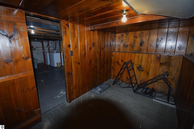 basement with separate washer and dryer and wood walls