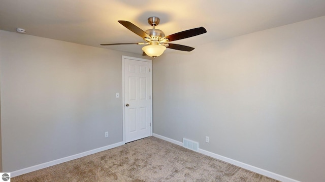 carpeted spare room with ceiling fan