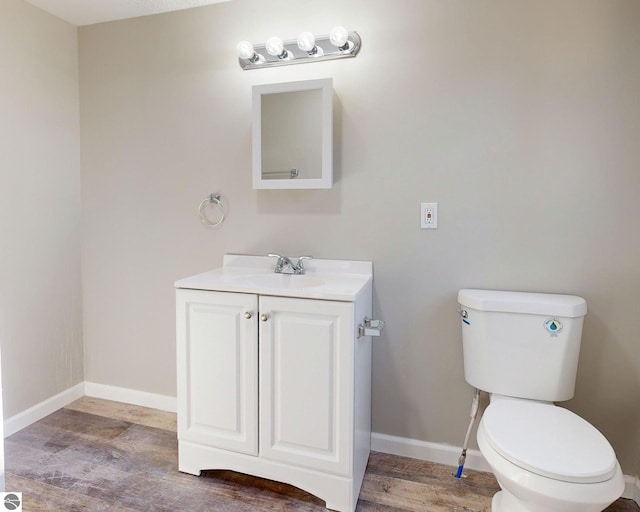 bathroom featuring vanity, hardwood / wood-style flooring, and toilet