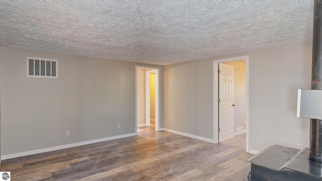 spare room featuring wood-type flooring and a textured ceiling