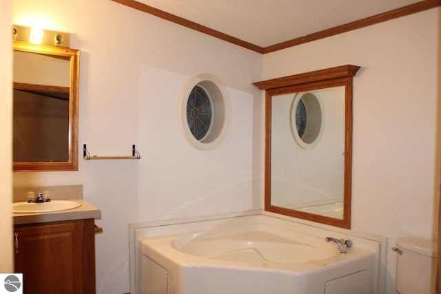 full bathroom with a garden tub, toilet, crown molding, and vanity