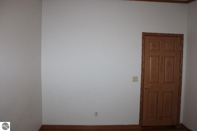 spare room with wood finished floors and baseboards