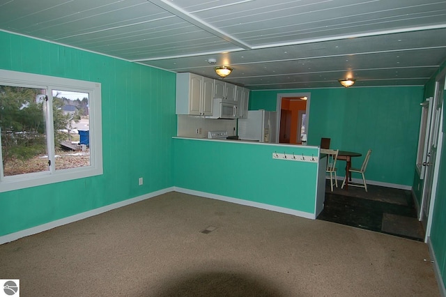 kitchen with carpet flooring, white appliances, and white cabinetry