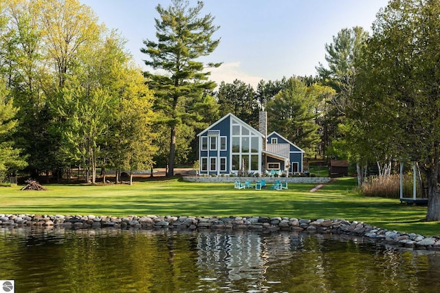 rear view of property featuring a yard and a water view