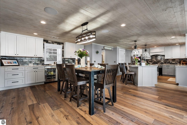 dining area featuring beverage cooler and light hardwood / wood-style floors